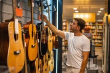 Man choosing guitar in music shop