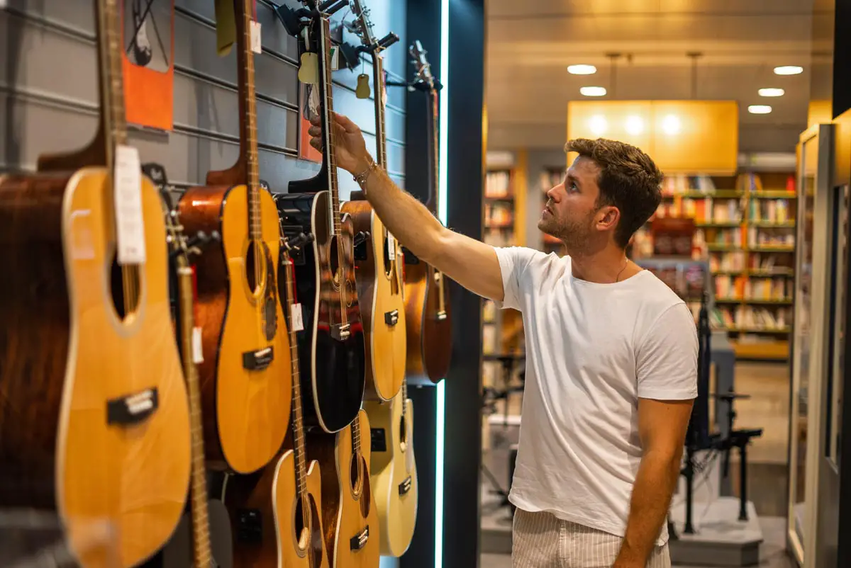 Man choosing guitar in music shop