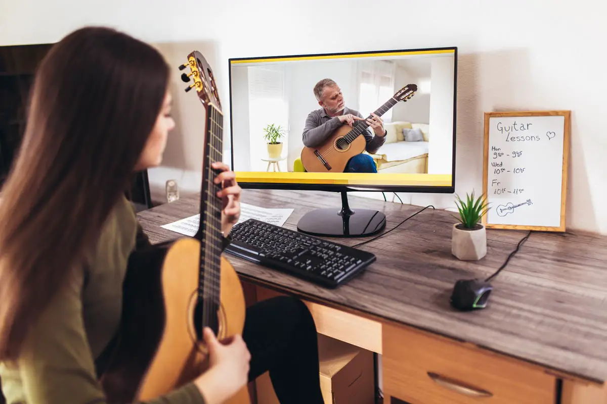 girl learning acoustic guitar with online course