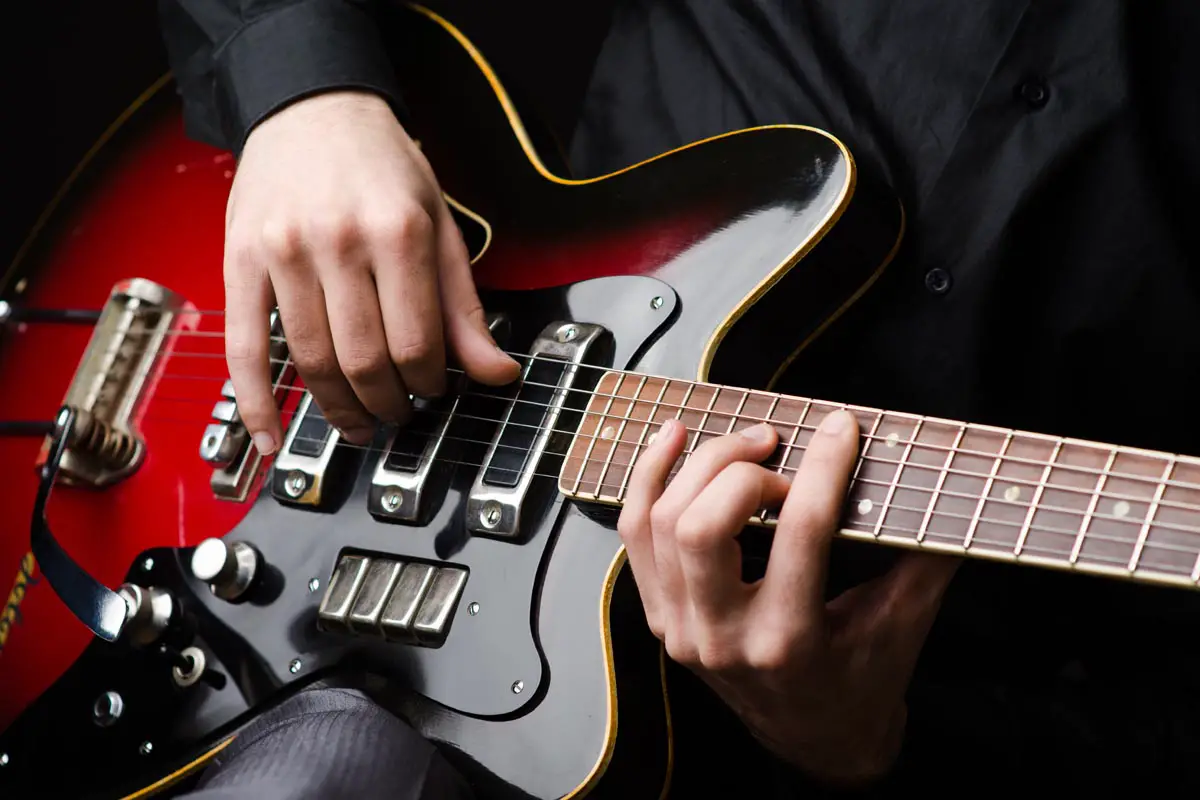 Man fingerpicking electric guitar during concert