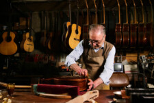 A luthier building high quality acoustic guitars in his workshop