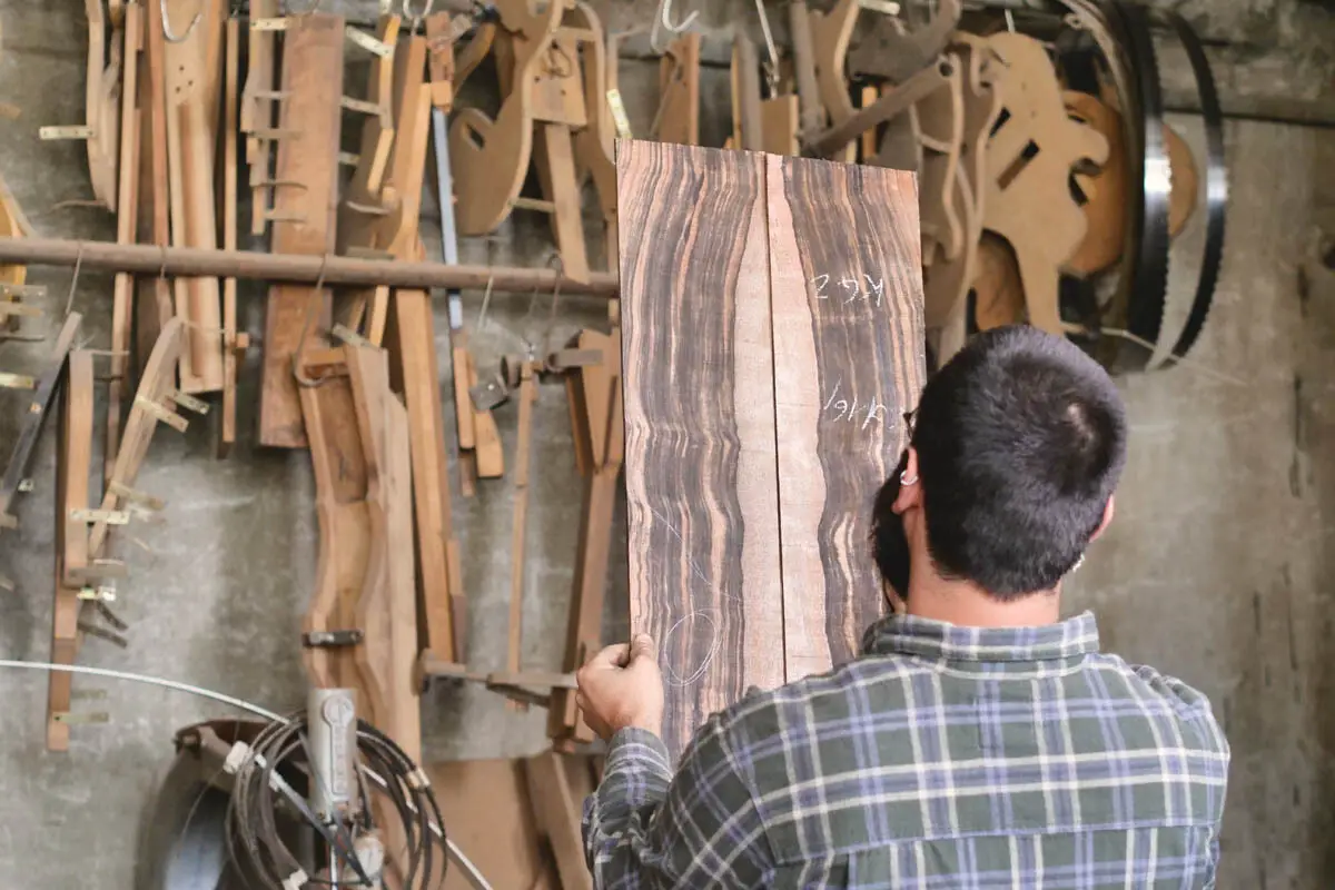 Luthier bookmatching select tonewood for a guitar