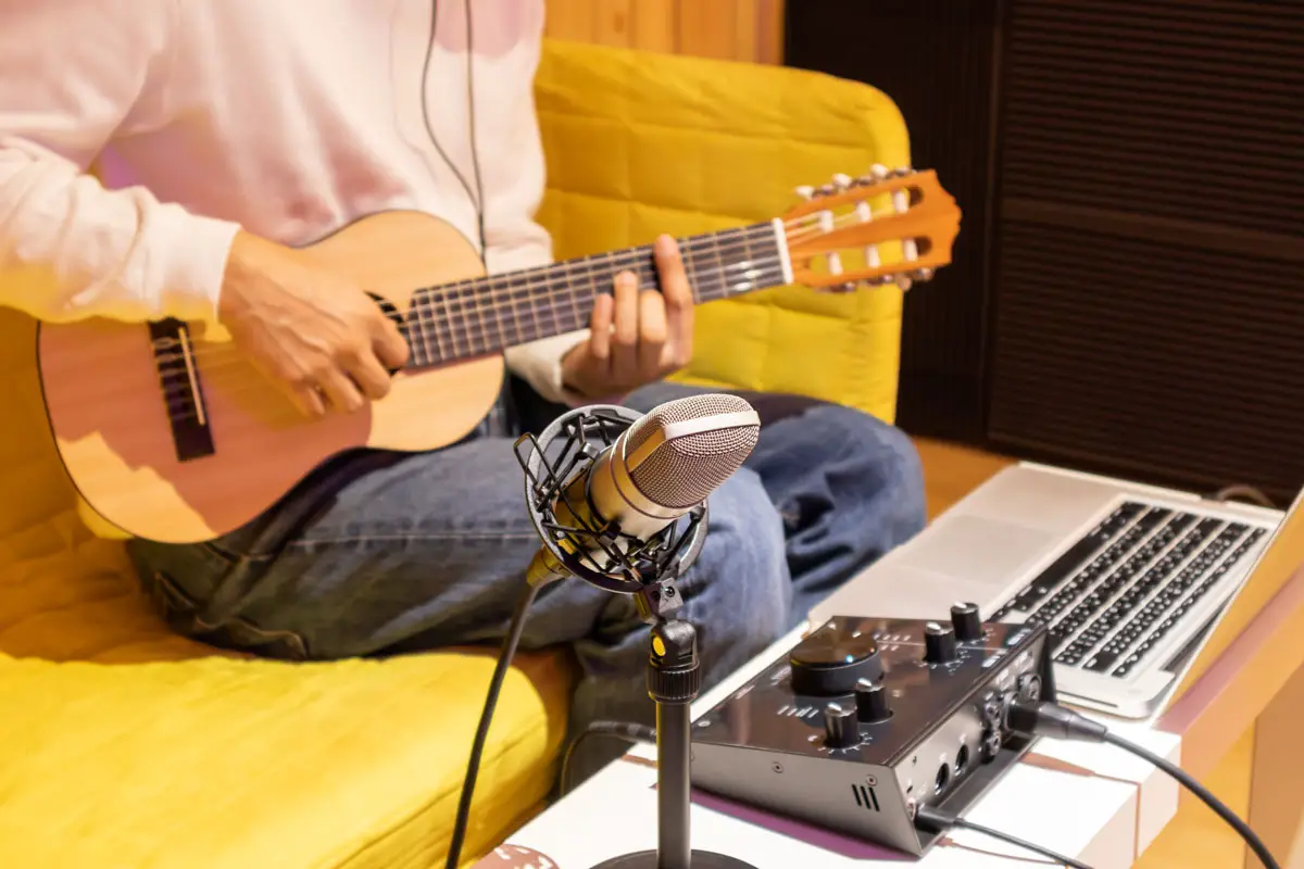 Man playing ukelele through audio interface for guitar